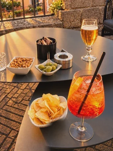 Aperitivo med spritz, chips og oliven på et bord i Caprarola