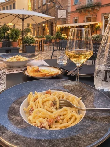 Tallerken med pasta og vinglas på restaurant i Caprarola
